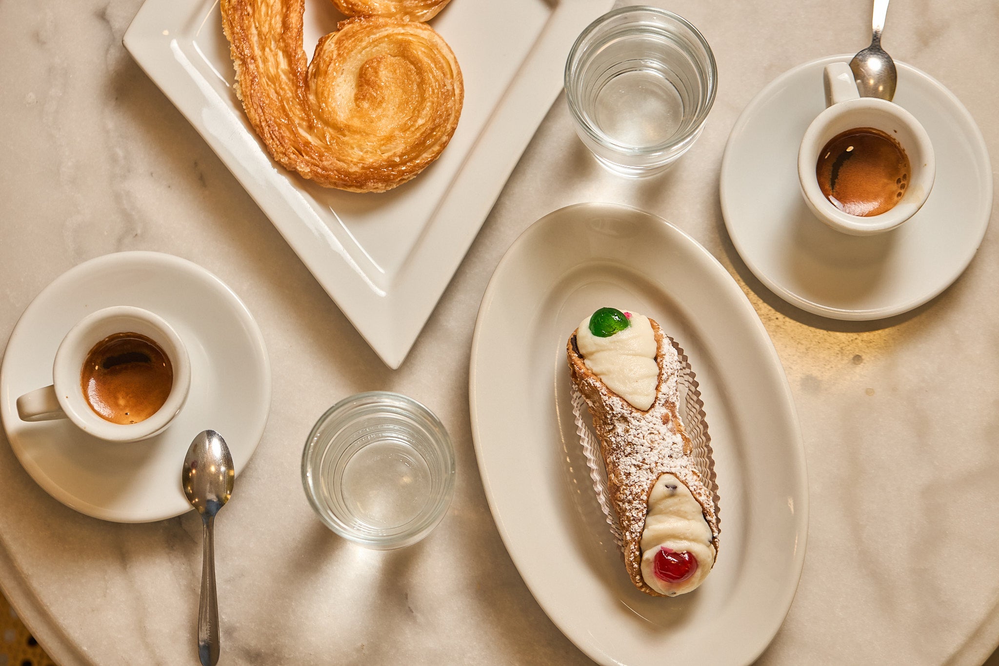 Colazione artigianale Pasticceria Tesi con caffè, cannolo siciliano e dolce tipico serviti su tavolino.